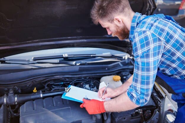 Mechanic writing something down next to the car