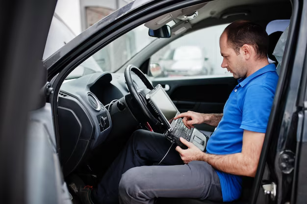 A man checks the serviceability of a car through a computer